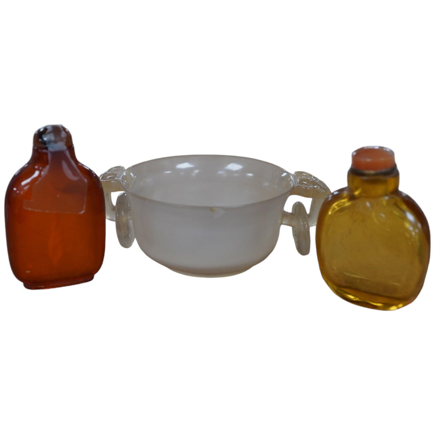 Two Chinese snuff bottles, amber and orange glass, and a similar bowenite bowl, 8cm. Condition - fair